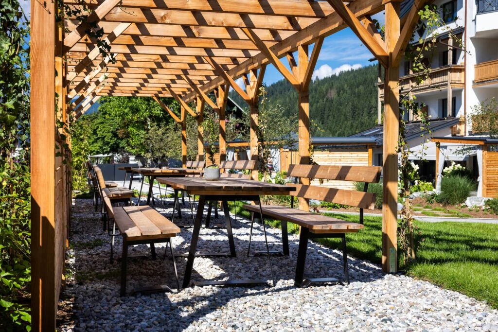 Gemütliche Gartenbänke mit Pergola aus Holz im Garten