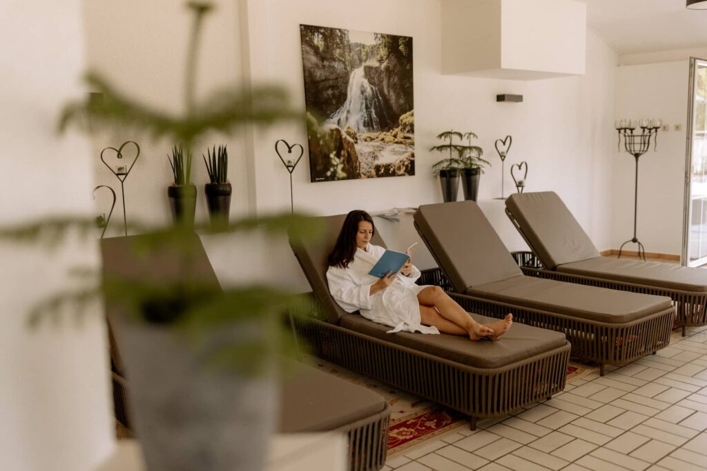 Frau genießt Urlaub auf Liege im Wellnessbereich
